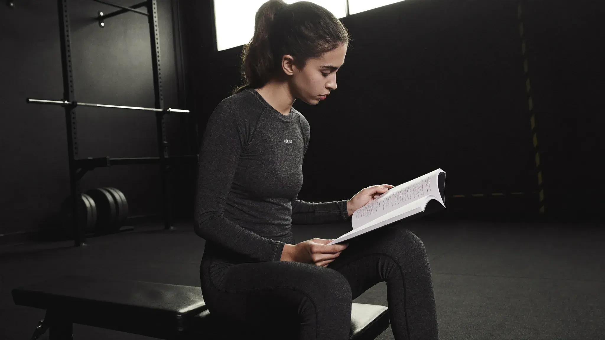 Woman reviewing a training log in a gym - Christian women strength training for stewardship, not aesthetics