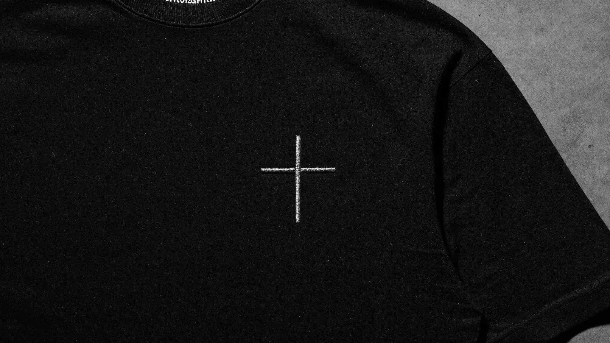 Alpha Omega Signature Tee laid flat showing the iconic cross design - faith-driven gym apparel