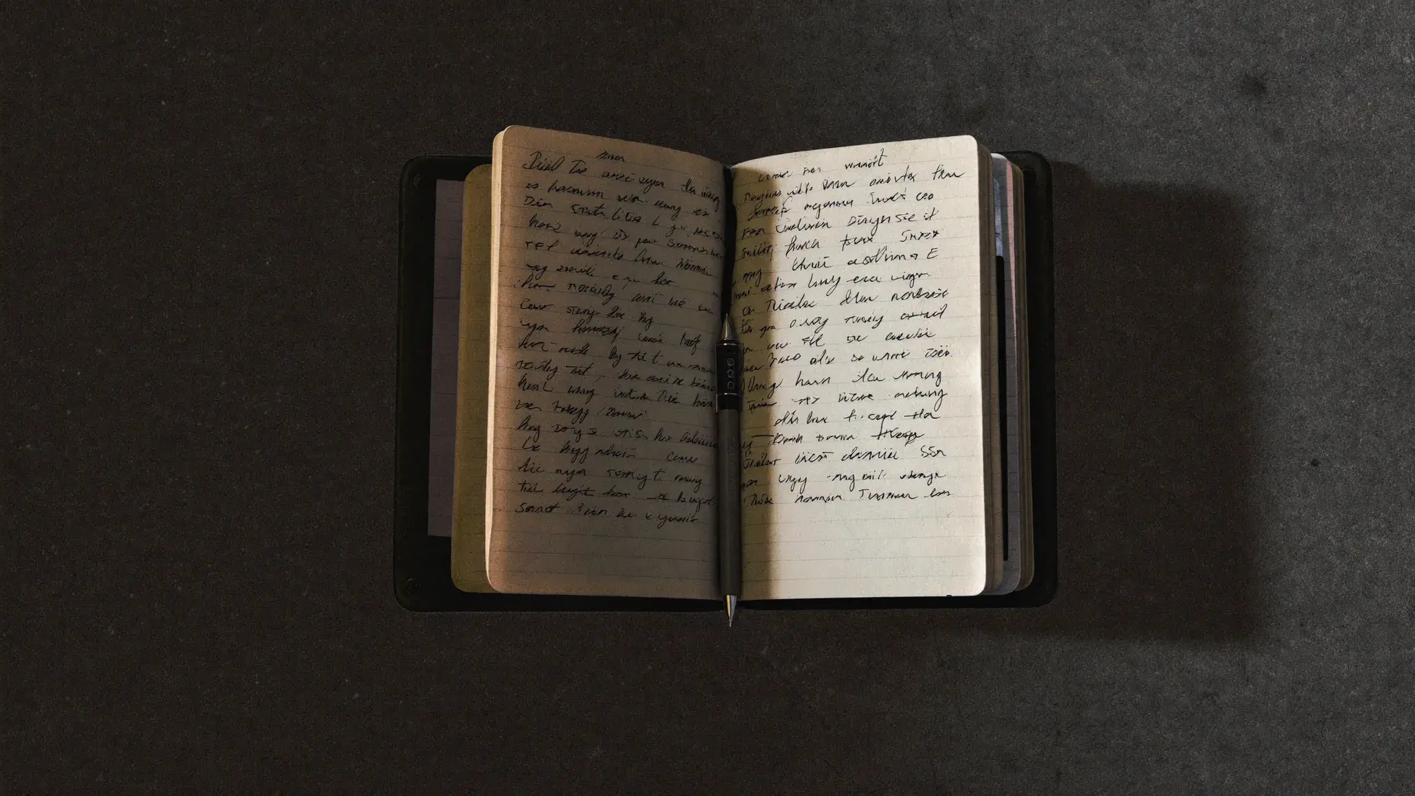 Open training journal on a gym floor beside a barbell - planning and process discipline in long-term faith-driven training