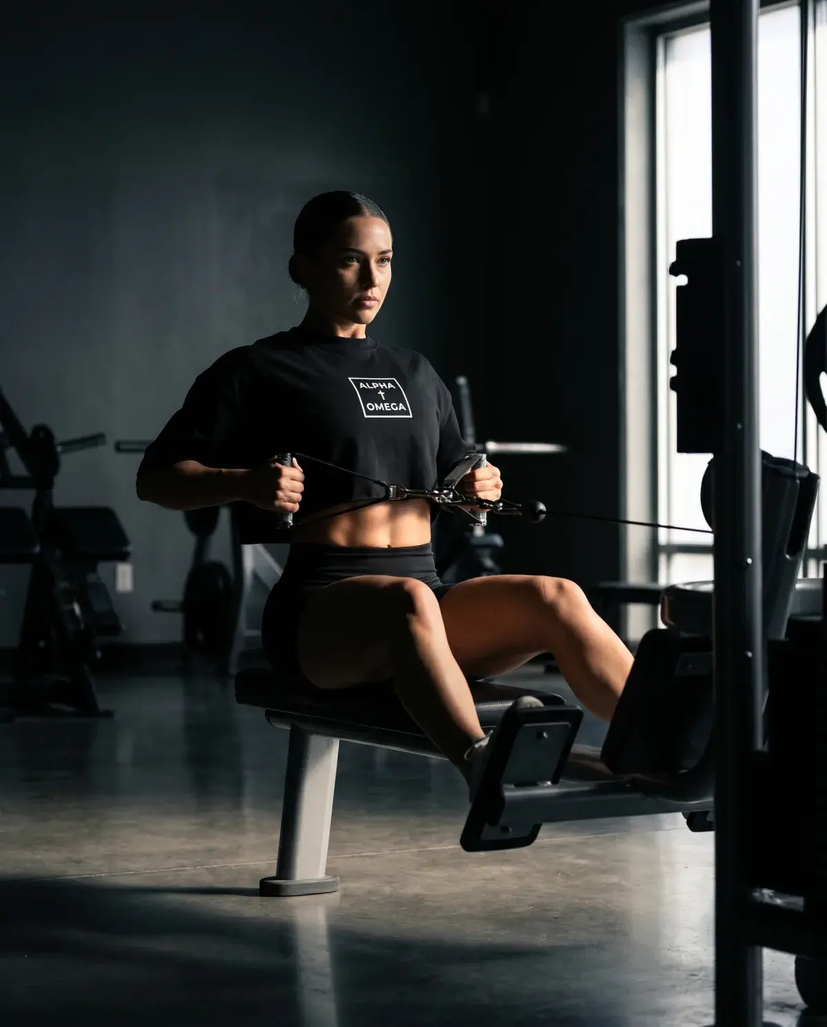 Athlete on the cable row in the black Alpha Omega gear