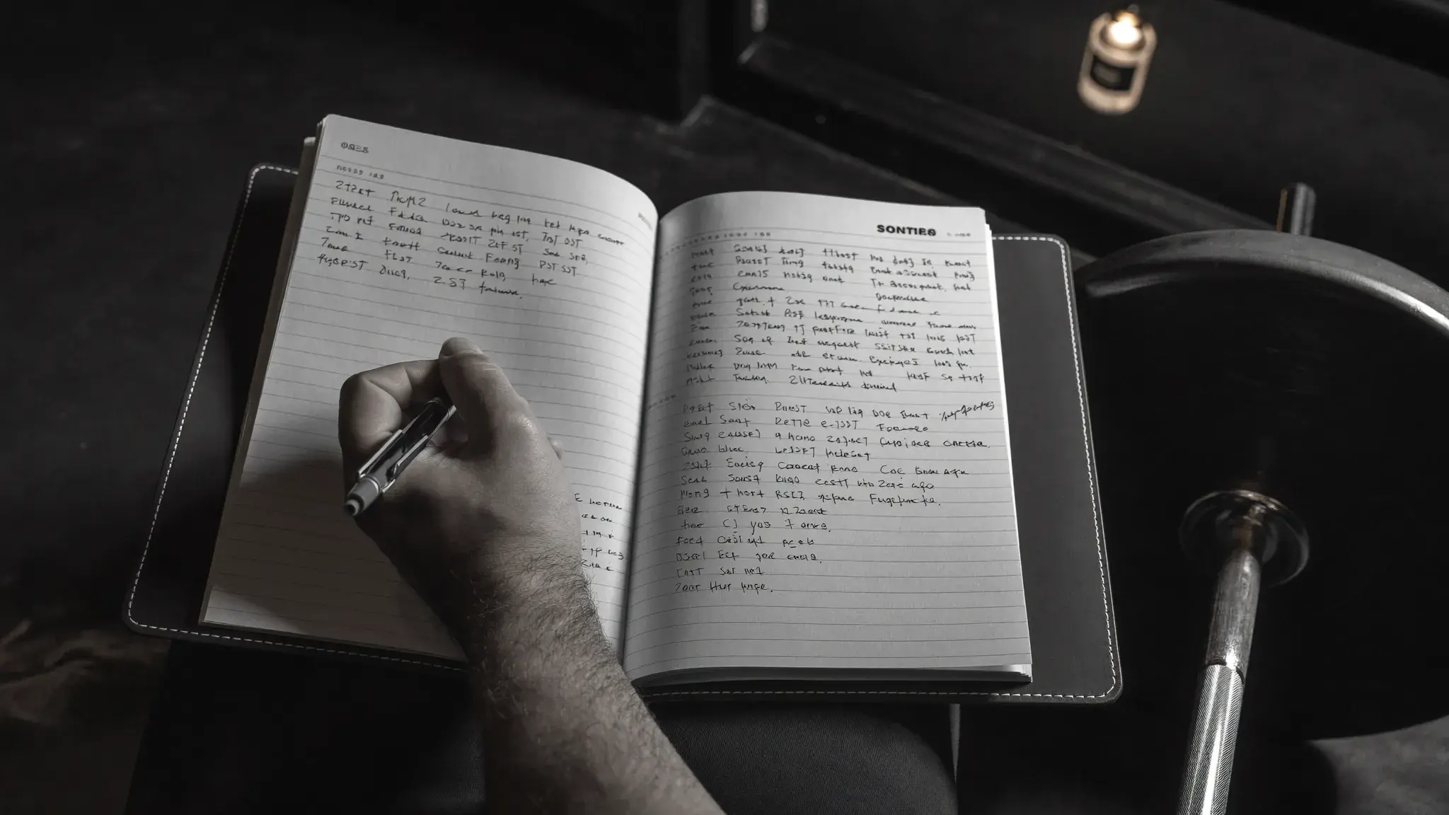 Lifter writing in a training log beside a loaded barbell - tracking progressive overload methods